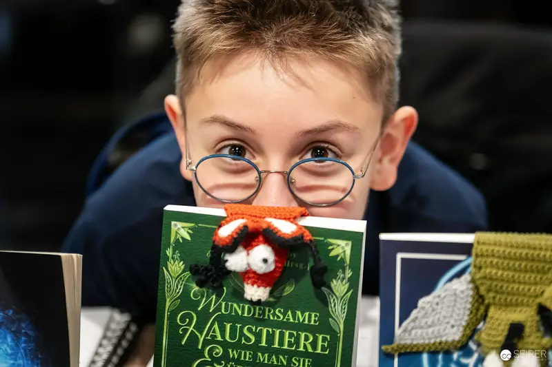 Young Reader Exploring Wondrous Animal Worlds Through Vintage Glasses and Book