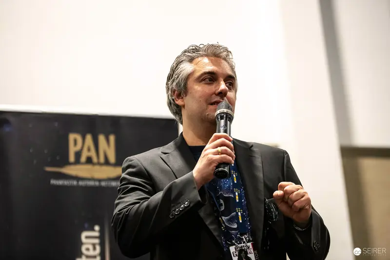 Speaker at PAN Event Delivering Presentation with Microphone