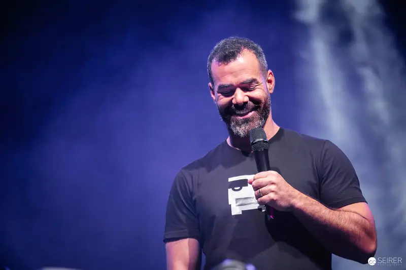 Comedian Performing at Vienna ComicCon 2023 with Microphone and Energetic Smile