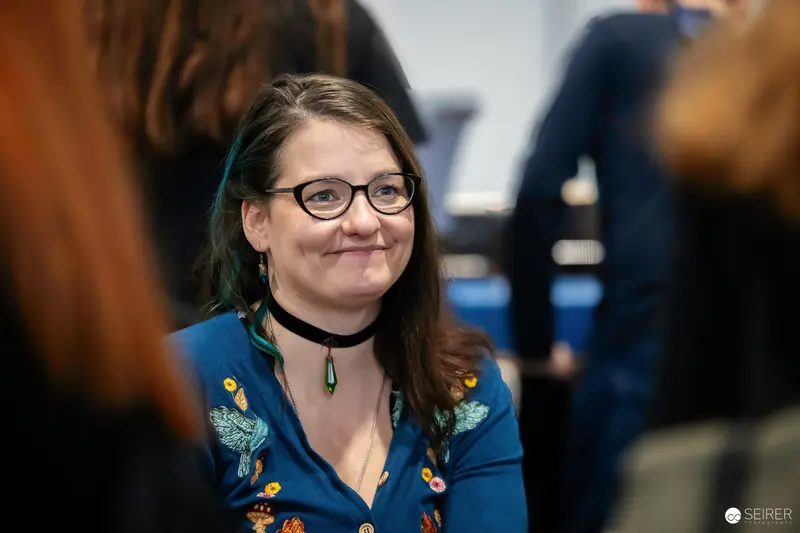 Smiling Woman in Blue Floral Top at Vienna ComicCon 2023