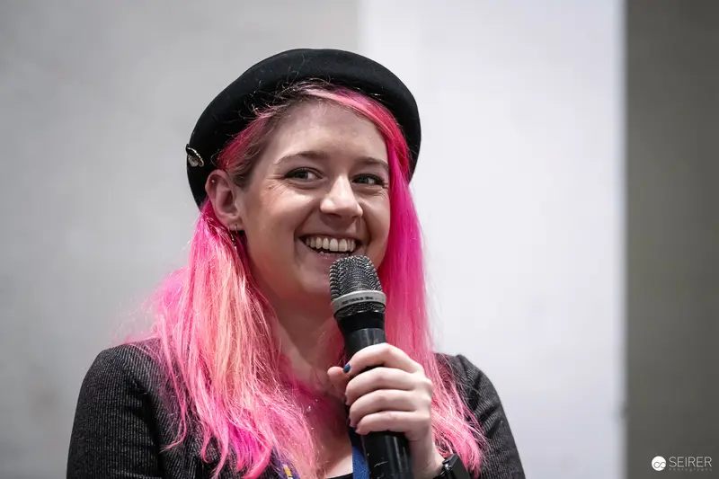 Pink-Haired Performer Speaking at Vienna ComicCon 2023 Microphone Event