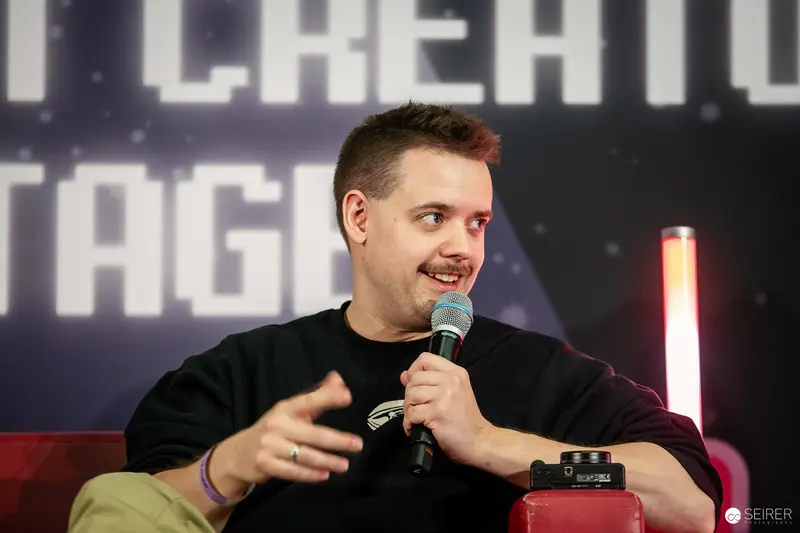Comic Con Speaker Engaging Audience with Animated Gesture During Panel Discussion