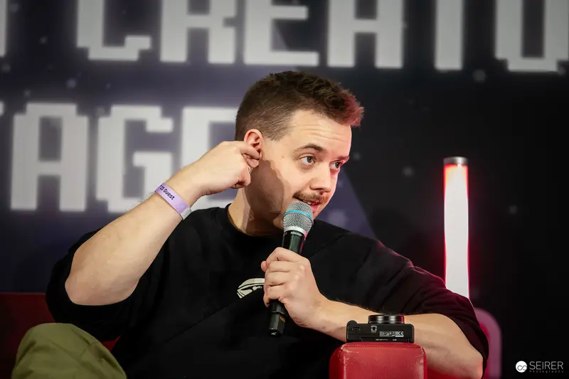 Speaker at VIECC Comic Convention Discusses with Microphone and Contemplative Gesture