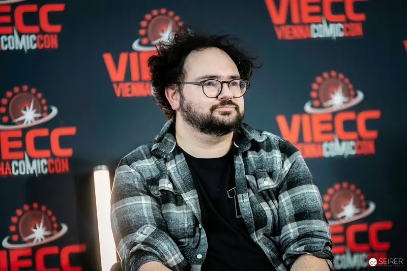 VIECC Vienna Comic Con 2023: Subject in Plaid Shirt at Press Event Backdrop
