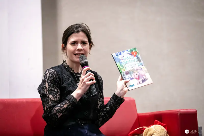 Vienna ComicCon 2023: Author Speaking with Microphone and Publication