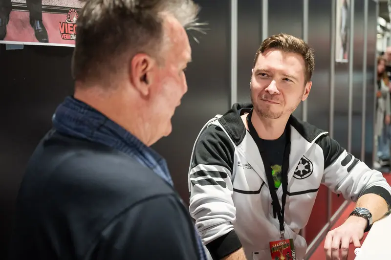 Two Men Conversing at Vienna ComicCon 2023 Exhibition Space