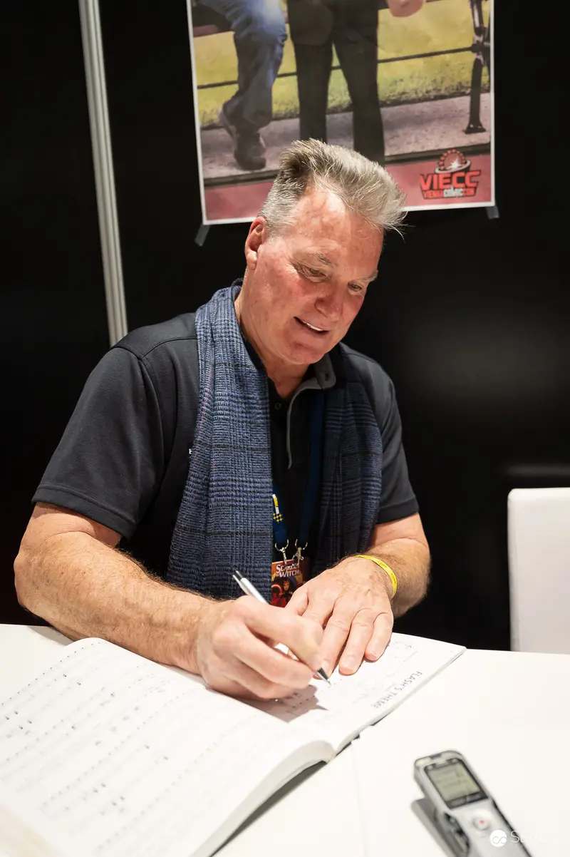 Man Writing and Recording at Vienna ComicCon 2023 Signing Table