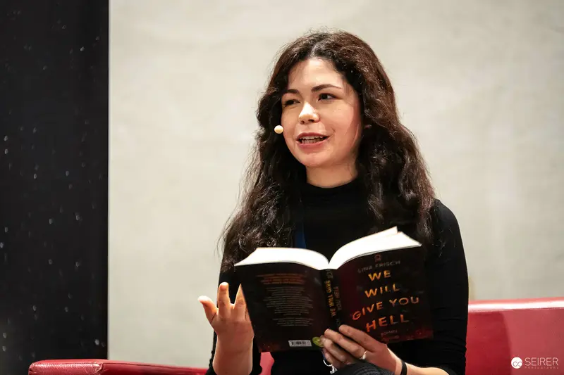 Woman Reading "We Will Give You Hell" Book at Public Event