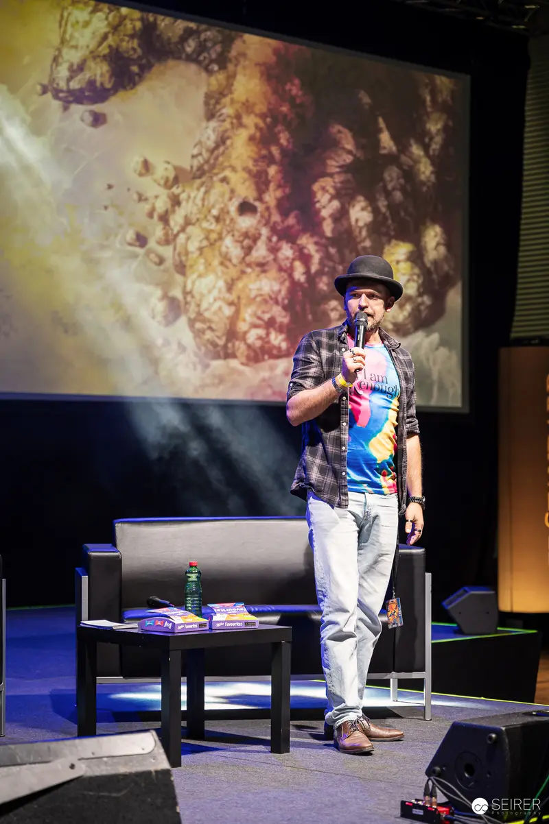 Host in Bowler Hat Presenting on Stage at VIECC Vienna Comic Con 2023