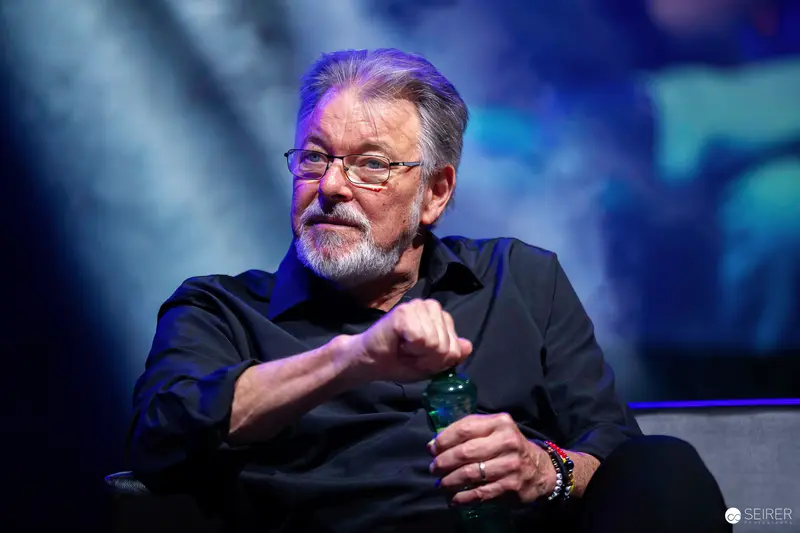 Grey-bearded panel guest gestures during Q&A at Vienna Comic Con 2023