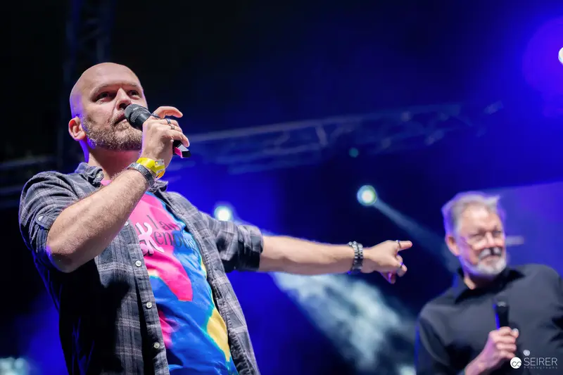 Moderator with Microphone Pointing to Audience on Main Stage at VIECC Vienna Comic Con 2023