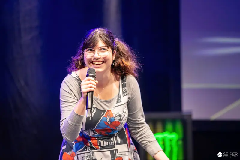 Stage host with microphone in Spider-Man comic-print dress at VIECC Vienna Comic Con 2023