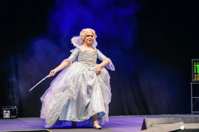 Fairy Godmother cosplayer with wand on the VIECC Vienna Comic Con stage, November 2023