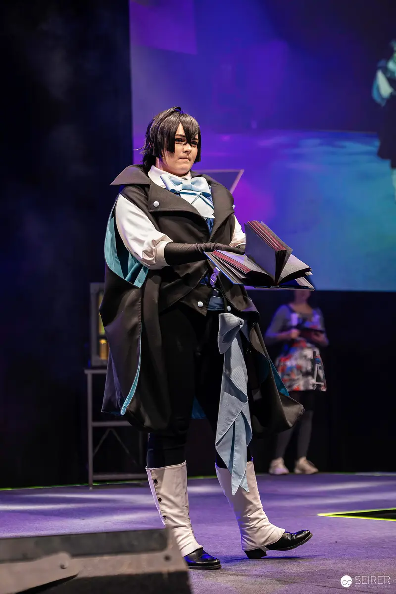 Cosplayer in Black Coat and Spats Presents Open Book on VIECC Vienna Comic Con Stage