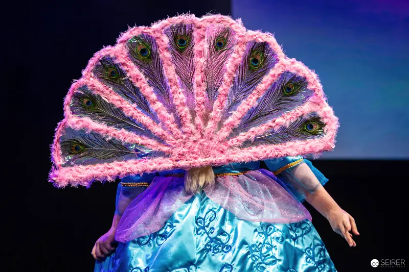 Cosplayer with Pink Peacock-Feather Fan on Stage at Vienna Comic Con 2023