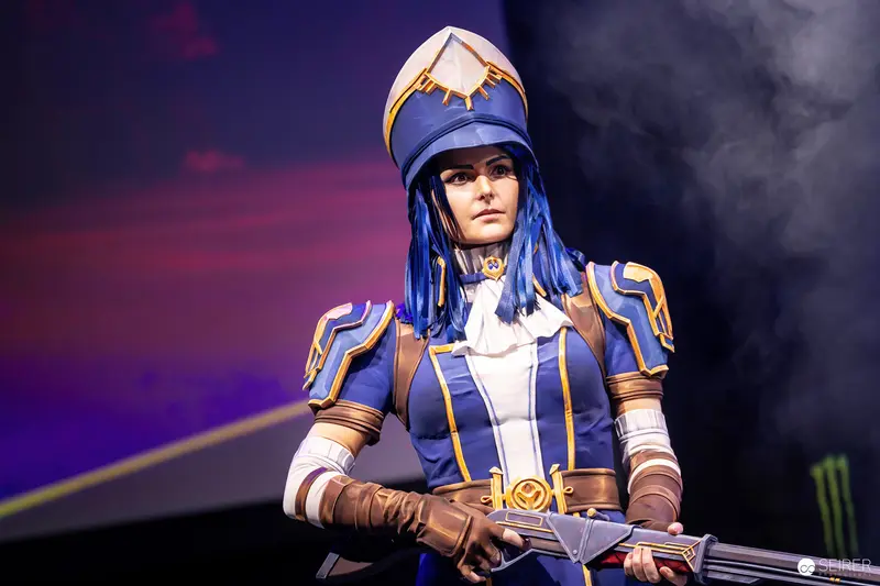 Blue-and-Gold Musketeer Cosplayer with Rifle on Stage at VIECC Vienna Comic Con 2023