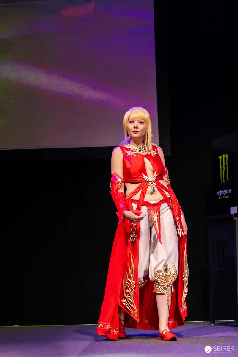 Cosplayer in red and gold fantasy costume on VIECC Vienna Comic Con stage