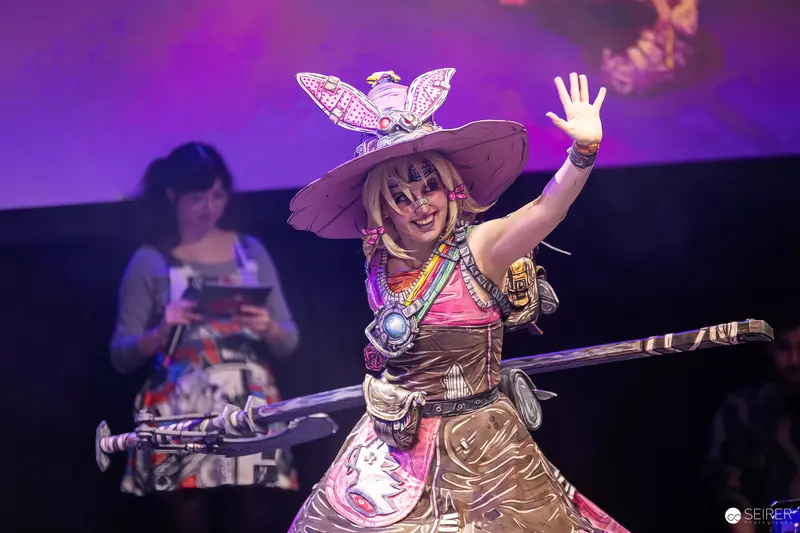 Cosplayer as Tiny Tina with Wide-Brim Hat Waving on VIECC Vienna Comic Con Stage
