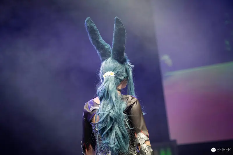 Cosplayer with tall rabbit ears and teal wig on stage at VIECC Vienna Comic Con 2023