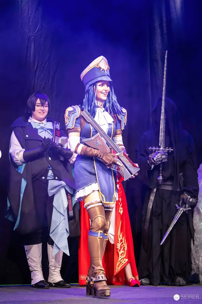 Cosplayer in blue military uniform with rifle on VIECC Vienna Comic Con contest stage
