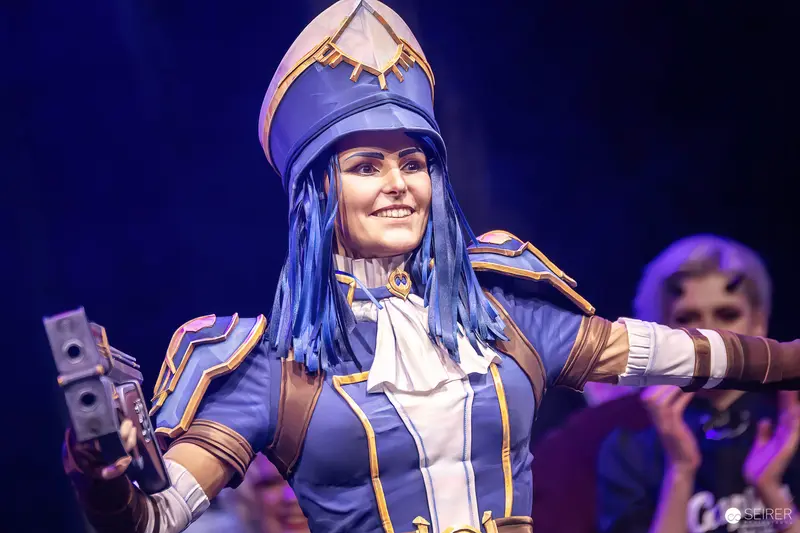 Cosplayer in blue-and-gold Caitlyn armour on the VIECC Vienna Comic Con stage