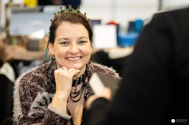 Cosplayer in emerald-jewelled crown and fur coat at VIECC Vienna Comic Con 2023