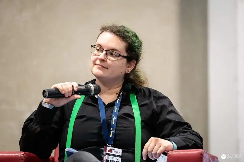 Panellist with Exhibitor Lanyard Holding Microphone at Vienna Comic Con 2023