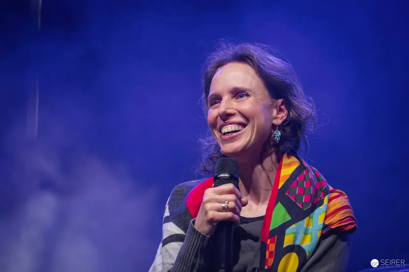 Panel host with handheld microphone on stage at VIECC Vienna Comic Con 2023