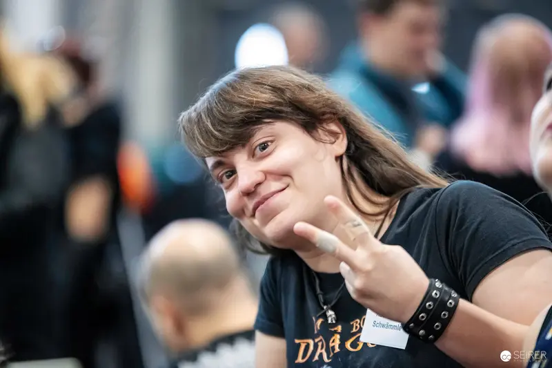Vienna Comic Con attendee with "Schwämmle" name badge making peace sign