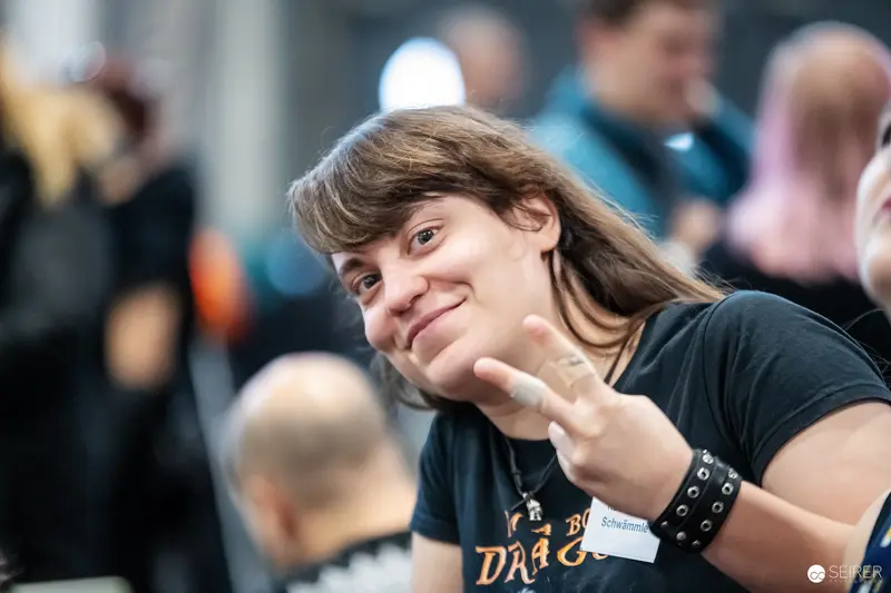 Attendee with "Schwämmle" name badge makes peace sign at VIECC Vienna Comic Con 2023