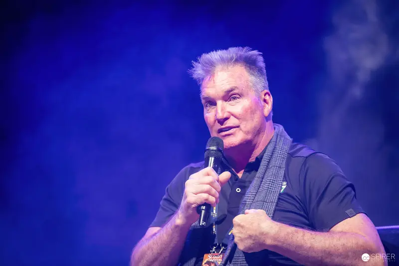 Guest actor speaking with handheld microphone on VIECC Vienna Comic Con panel stage