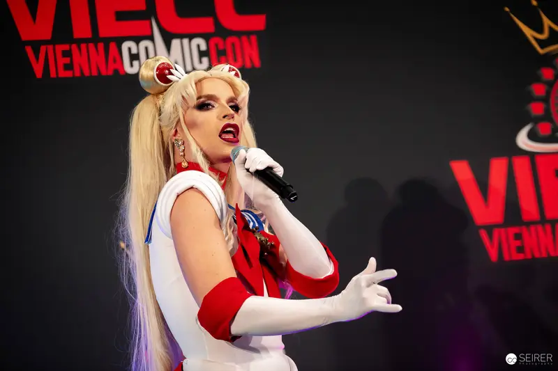 Sailor Moon cosplayer sings into microphone on VIECC Vienna Comic Con stage