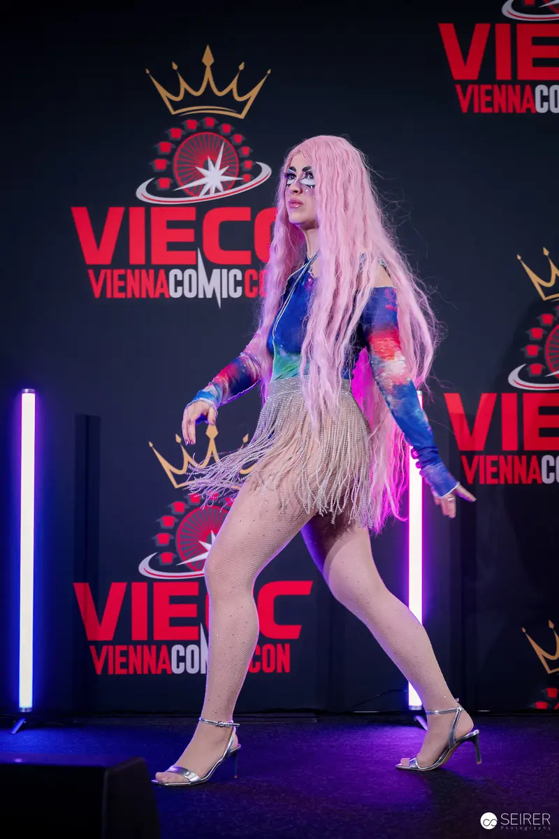 Cosplayer in Pink Wig and Fringed Bodysuit on VIECC Vienna Comic Con Stage