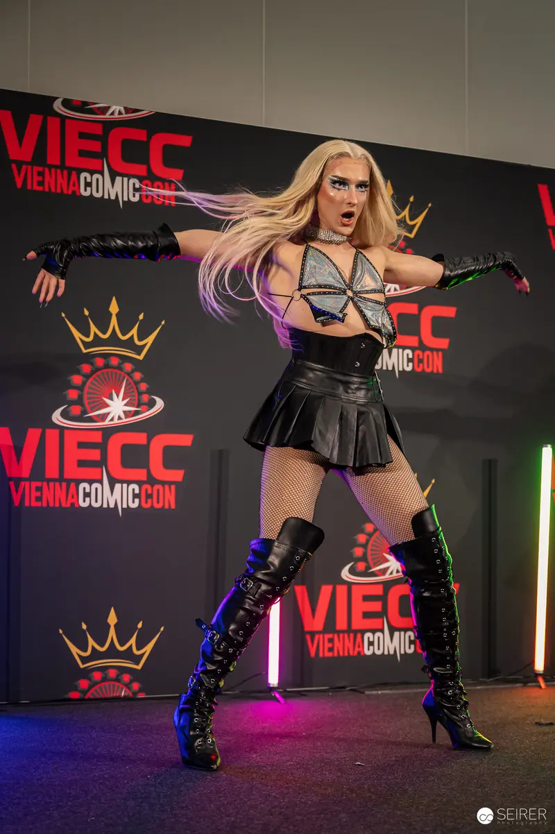 Cosplayer in black leather and thigh-high boots poses on VIECC Vienna Comic Con stage