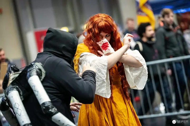Cosplay Duo in Yellow Gown and Black Hooded Costume, VIECC Vienna Comic Con 2023