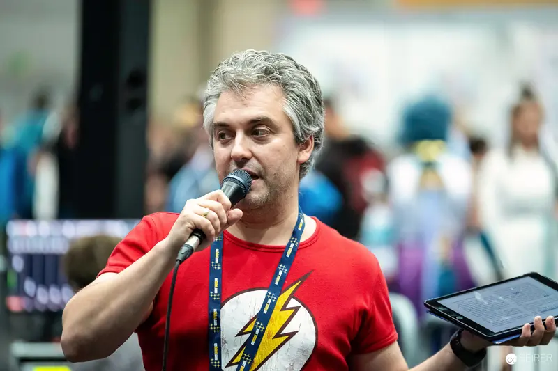 Host with Microphone and Tablet in Flash T-Shirt at VIECC Vienna Comic Con 2023