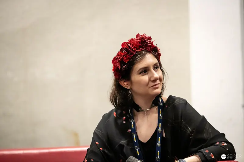 Attendee in red flower crown and event lanyard at VIECC Vienna Comic Con 2023