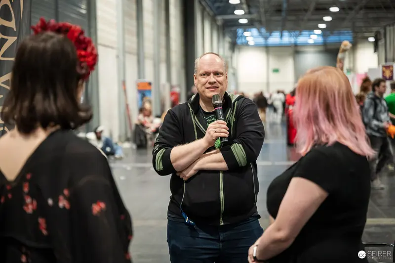 Interviewer with Microphone Speaking to Two Attendees at VIECC Vienna Comic Con 2023