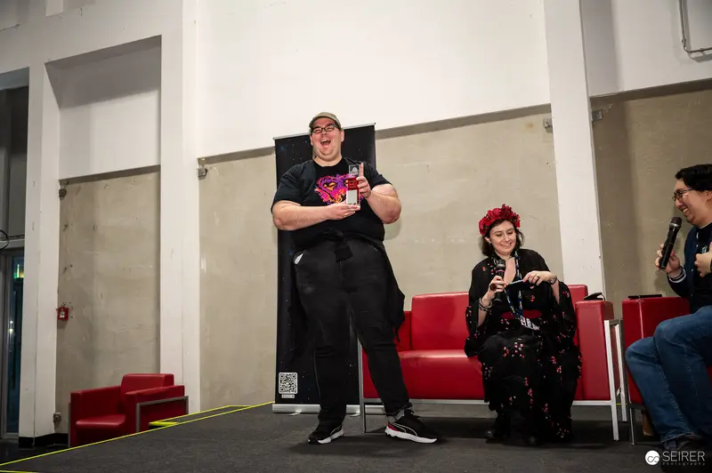 Cosplay contest winner holding trophy on stage at VIECC Vienna Comic Con 2023