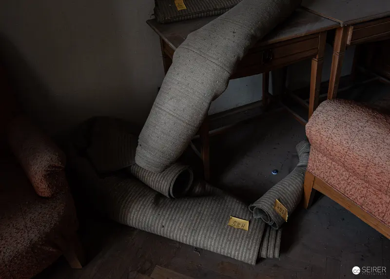Rolled carpets with inventory tags stored in a Südbahnhotel Semmering room, November 2023