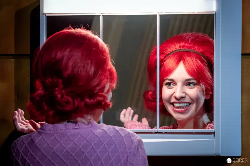 Vibrant Red-Haired Woman Smiling in Mirror Reflection