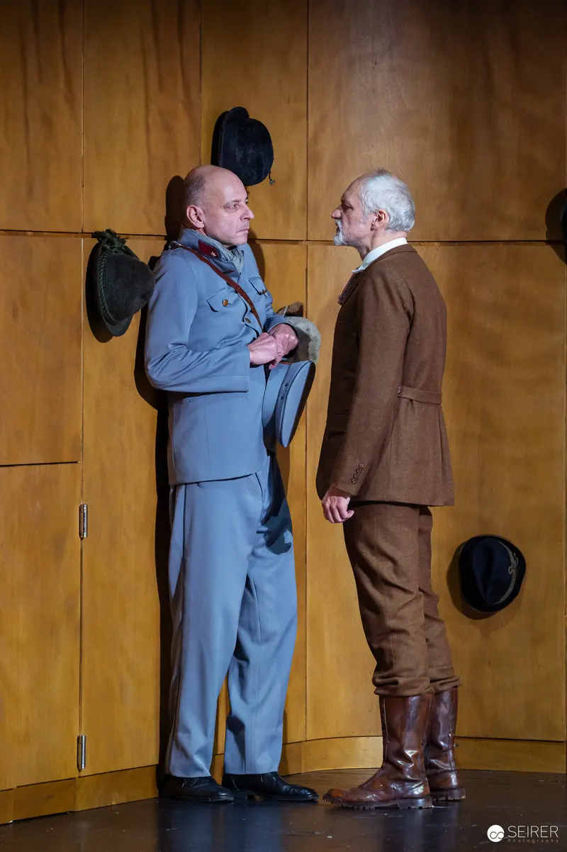Two Men in Period Costumes Conversing Intensely During Der Himbeerpflücker Theater Performance