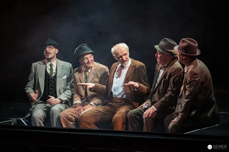 Der Himbeerpflücker Cast Seated in Dramatic Theatrical Staging