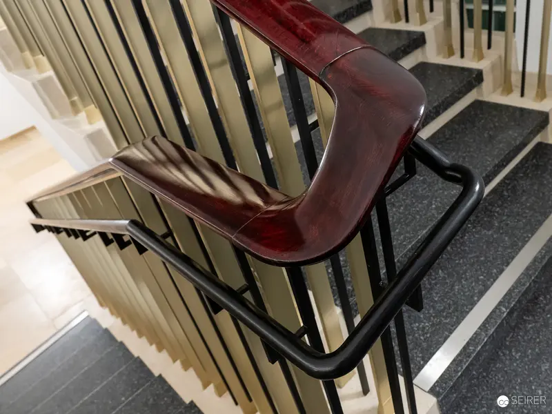 Ornate Wooden Handrail Curves Along Staircase in Modern Interior