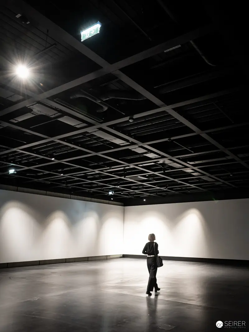 Solitary Figure in Minimalist Gallery Space During Wien Museum Preopening