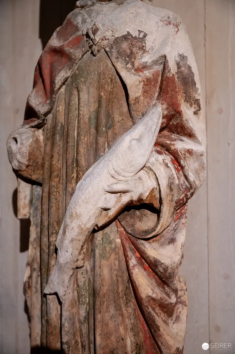 Medieval Religious Sculpture with Draped Fabric and Weathered Surface
