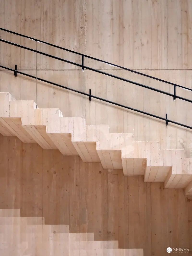 Minimalist Wooden Staircase with Black Metal Railing in Modern Interior