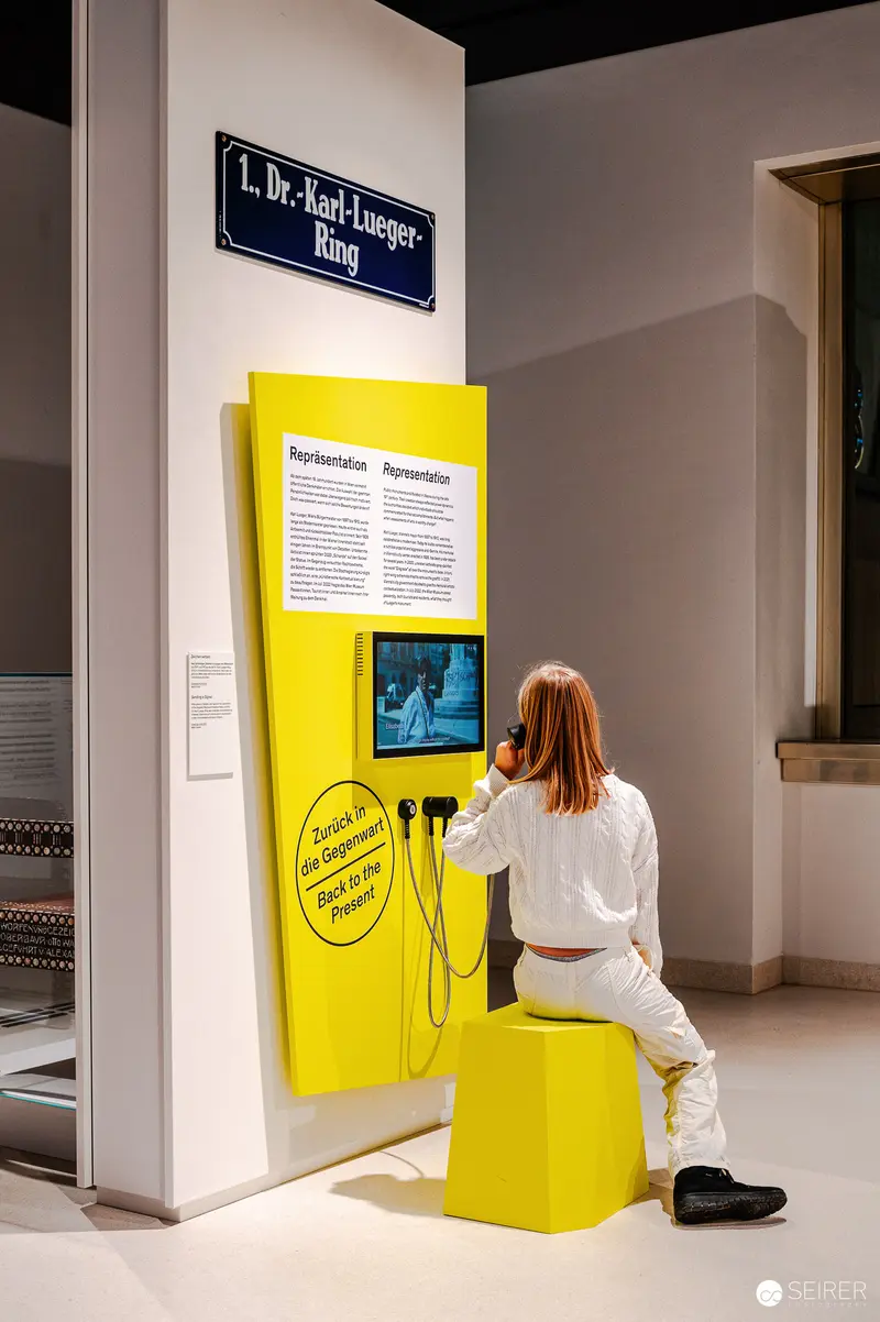 Wien Museum Visitor Explores Interactive Yellow Exhibition Display Panel