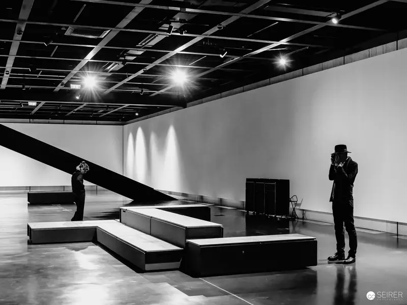 Two Figures in Minimalist Exhibition Space at Wien Museum