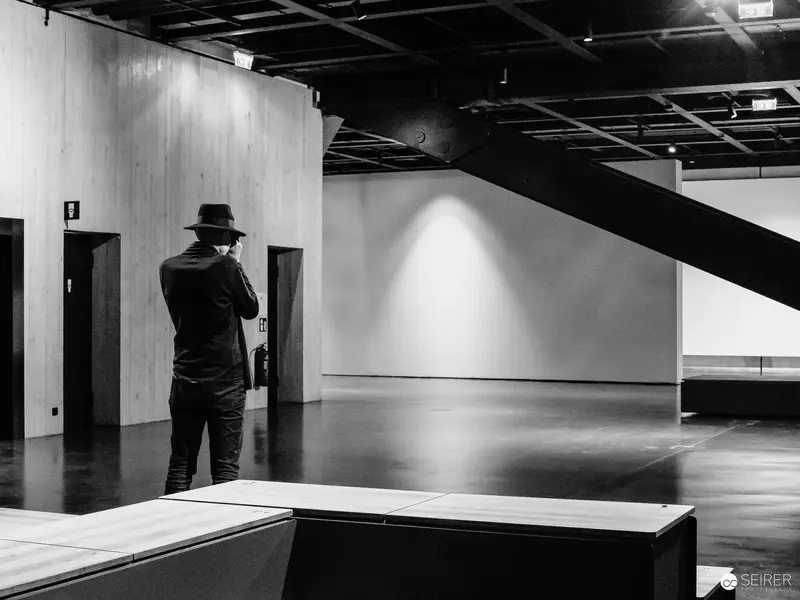 Solitary Figure in Minimalist Gallery Space with Angular Architecture
